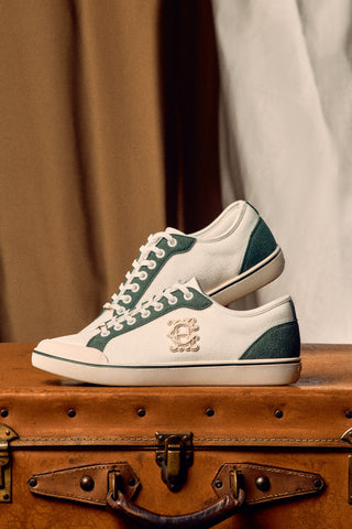 White sneakers with green accents on a vintage suitcase