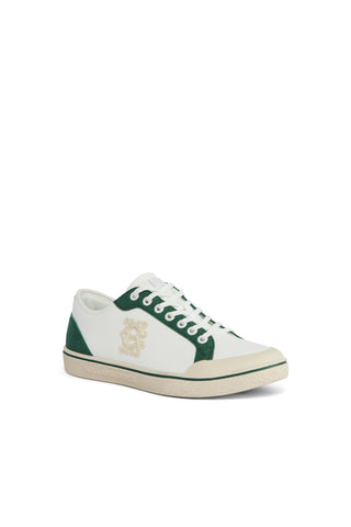 White sneaker with green accents on a white background
